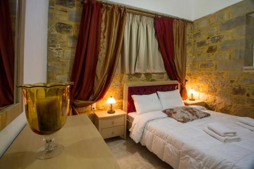a bedroom with a bed and two tables with lamps at Agarathos Traditional Rooms with Pool in Kissamos