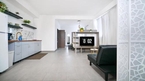 a kitchen and a living room with a black chair at Caribbean Stars San Juan Airport in Carolina