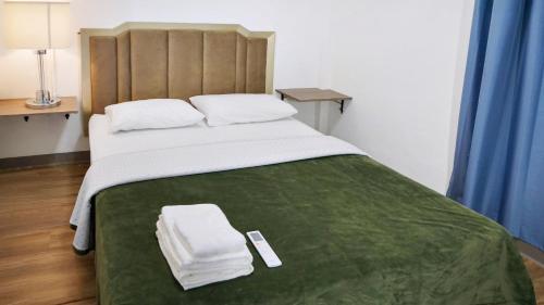 a bedroom with a large bed with two towels on it at Caribbean Stars San Juan Airport in Carolina