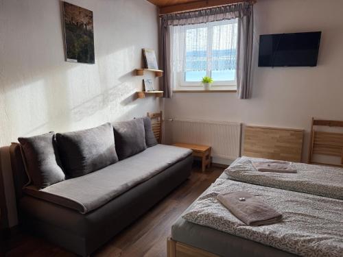 a living room with a couch and a bed at Pension Hones in Horská Kvilda