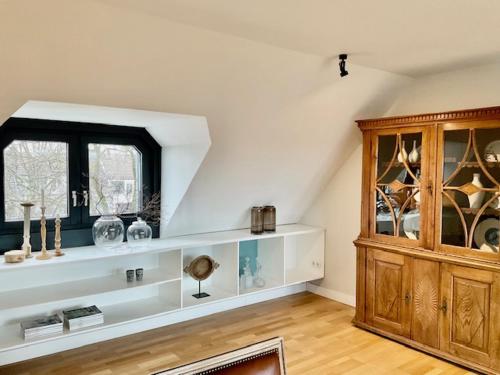 a room with a shelf with vases and a window at Charmante Penthouse Wohnung in Krefeld