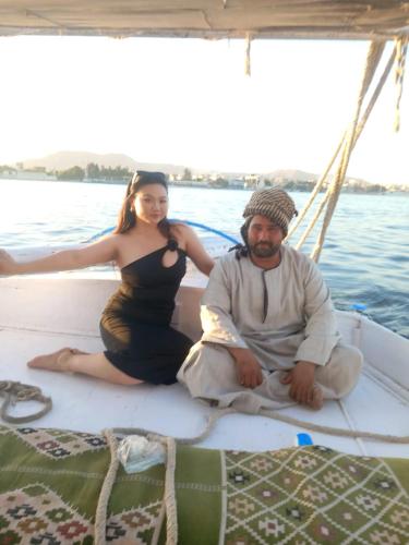 a man and a woman sitting on a boat at جزيرة العوامية in Luxor