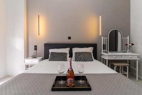 a bed with a tray with a bottle and two glasses at Gkr Luxury Apartments Metro Petralona in Athens