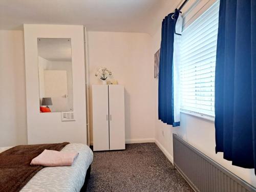 a bedroom with a dresser and a blue curtain at 2 Bedroom House in Leeds - Sleeps 5 WiFi Parking in Leeds