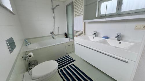 a white bathroom with a sink and a toilet at House with 5 bedrooms near Brussels in Wemmel