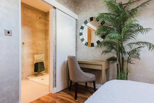 a bedroom with a desk and a chair and a plant at Central Knutsford Apartment in Knutsford