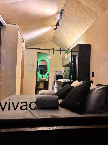a large bed in a room with a green light at Tiny House Minimalista en la Naturaleza, El Retiro in El Retiro