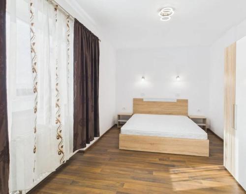 a bedroom with a bed and a wooden floor at Unique apartments in Timişoara