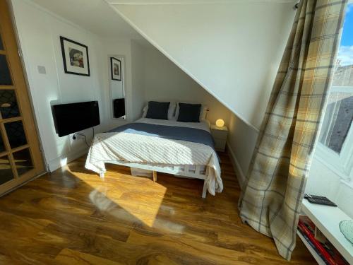 ラーグスにあるLargs Top Floor Flatのベッドと薄型テレビのある寝室
