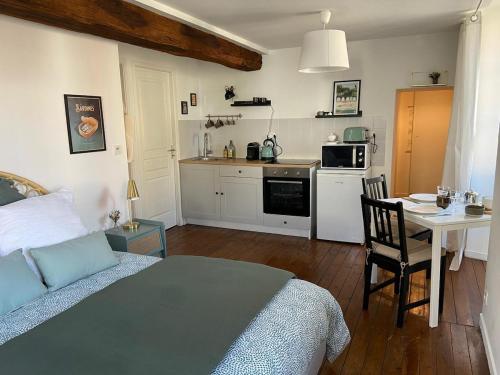 une chambre avec un lit et une table et une cuisine dans l'établissement La Bohème ô coeur du centre ville, aux Herbiers