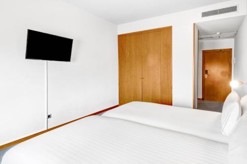 a bedroom with a bed with a tv on the wall at B&B HOTEL Barcelona Mollet Porta de Gallecs in Mollet del Vallès