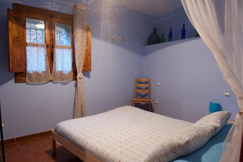 a bedroom with a bed and two windows at Casa Rural Valle del Arrago in Robledillo de Gata