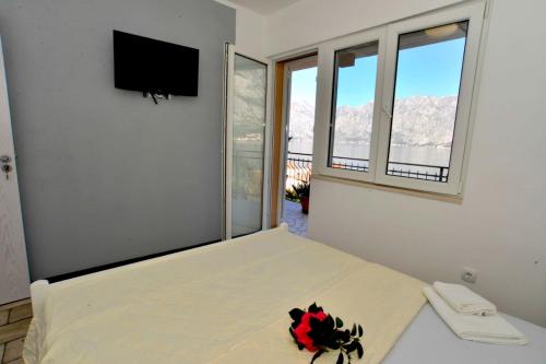 a bedroom with a bed with a tv on the wall at Apartments Boka bay in Kotor