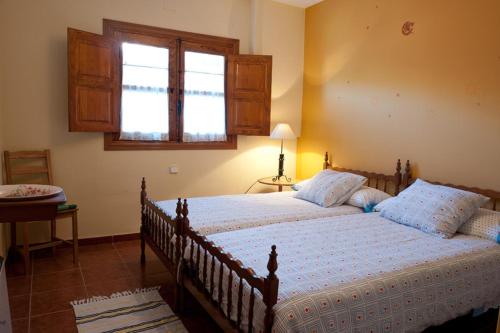 a bedroom with a large bed with a window at Casa Rural Valle del Arrago in Robledillo de Gata