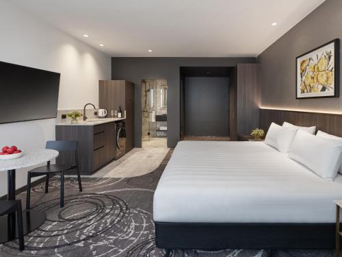 a hotel room with a large bed and a kitchen at PARKROYAL Monash Melbourne in Clayton North
