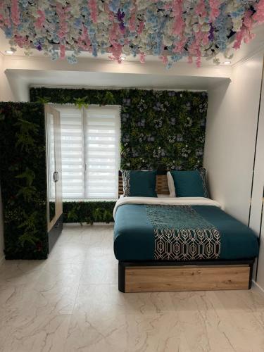 - une chambre avec un lit orné d'un mur fleuri dans l'établissement Apartment with jacuzzi, à Lille