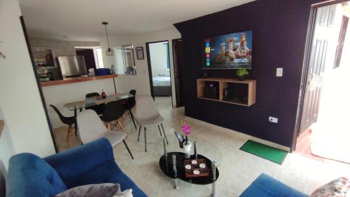 un salon avec un canapé bleu et une table dans l'établissement Apto piso 2 amoblado en Bucaramanga, à Bucaramanga