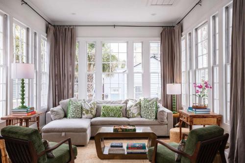 a living room with a couch and chairs and windows at The Aviary at CasaZoe in Charleston