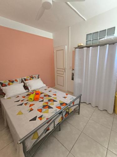 a bedroom with a bed with a colorful comforter at Gite Beauvallon in Basse-Terre