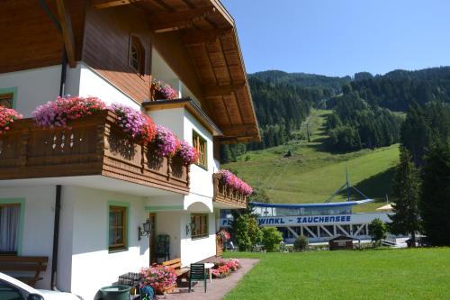 a building with flowers on the balconies of it at Holiday-Appartements in Flachau