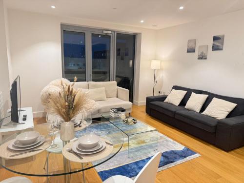 a living room with a couch and a glass table at Auracasa 2 Bed O2 Canning suite in London