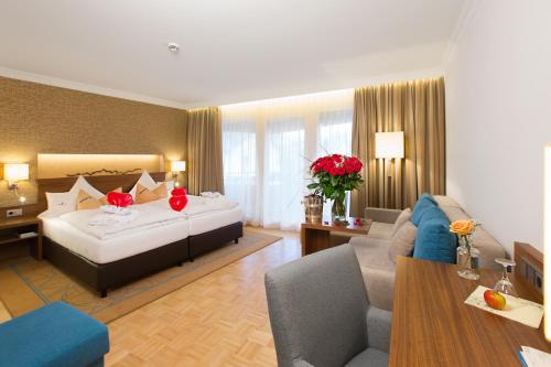 a hotel room with a bed and a couch at AKZENT Hotel Restaurant Altdorfer Hof in Weingarten