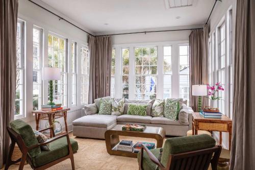 a living room with a couch and chairs and windows at Casa Zoe in Charleston