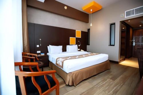 a hotel room with a large bed and a desk at Gold Crest Hotel in Mwanza