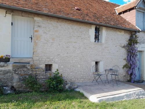 une maison en briques blanches avec une table et des chaises à l'extérieur dans l'établissement Charmante petite maison 2 personnes, à Chambourg-sur-Indre