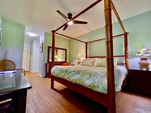 a bedroom with a canopy bed and a ceiling fan at 2 bedrooms Condo few mins walk to Beaches & Pool in Koloa
