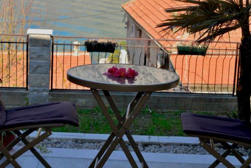 a table with flowers on top of it next to two chairs at Apartments Boka bay in Kotor