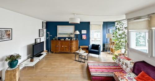a living room with a couch and a tv at Charmant logement avec vue jardin - proche du métro in Asnières-sur-Seine