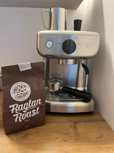a coffee maker and a bag on a counter at The Dream Whale Bay in Raglan