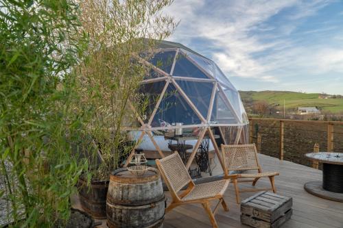 - un kiosque avec une table et des chaises sur une terrasse dans l'établissement du coq à l'âne, à Saint-Martin-la-Plaine