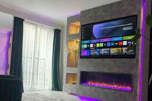 a living room with a flat screen tv on a wall at The Exclusive Jacuzzi Apartment in Birmingham