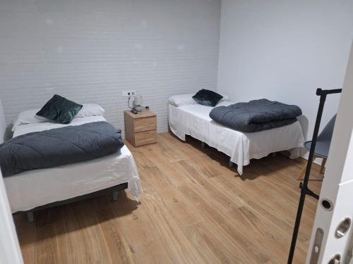 two beds in a room with wooden floors at casa dia in Valdeganga