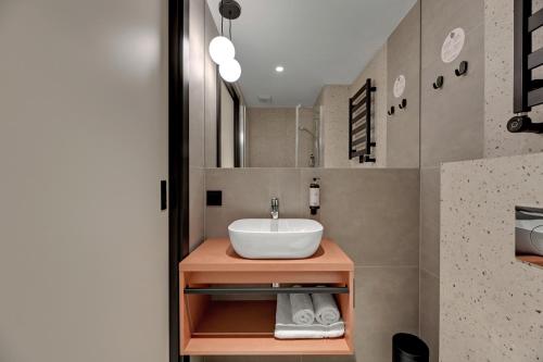 a bathroom with a sink and a mirror at Hotel Milo Gdansk Airport in Gdańsk