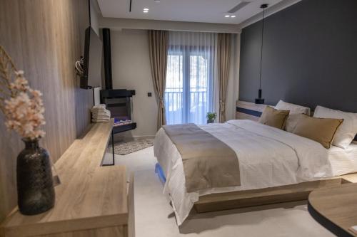 a bedroom with a large bed and a tv at Polyzos Luxury Suites Meteora #4 - Adults Friendly in Kalabaka
