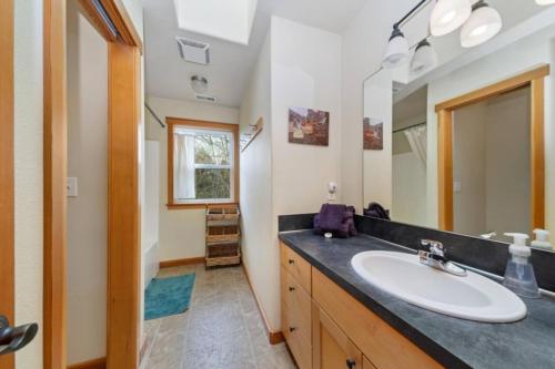 ein Badezimmer mit Waschbecken und Spiegel in der Unterkunft 3br Hot Tub Ocean Views & King Beds Near Beach in Nehalem