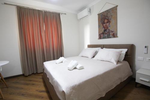 a bedroom with a bed with two towels on it at Villa Reve de Tirana in Tirana