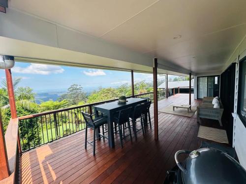 a balcony of a house with a table and chairs at Mountain Retreat Scenic Getaway with BBQ in Mount Tamborine