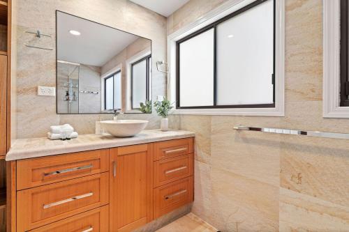 a bathroom with a sink and a mirror at Mountain Retreat Scenic Getaway with BBQ in Mount Tamborine