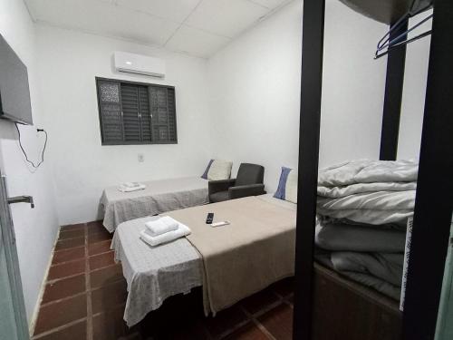 a small room with two beds and a table at New hotel in Alegrete