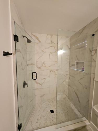 a bathroom with a shower with a glass door at Charming Marietta Square Carriage House in Marietta