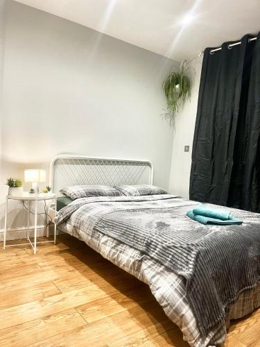 a bedroom with a bed with a blue blanket on it at Vf apartments kingsbury in The Hyde
