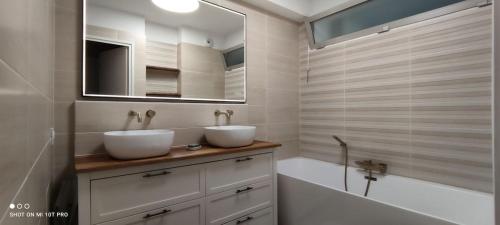 une salle de bain avec deux lavabos, une baignoire et un miroir dans l'établissement Chambre entre plage et Stade Vélodrome, à Marseille