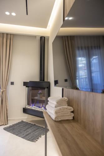 a living room with a fireplace and a pile of towels at Polyzos Luxury Suites Meteora #5 - Adults Friendly in Kalabaka