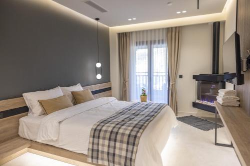 a bedroom with a large bed and a fireplace at Polyzos Luxury Suites Meteora #5 - Adults Friendly in Kalabaka