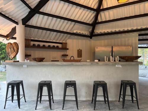 una sbarra con quattro sgabelli di fronte a un bancone di Coronado Hideaway with Private Pool a Las Lajas