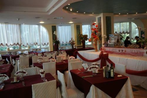 a restaurant with red and white tables and chairs at Hotel Lady Mary in Milano Marittima